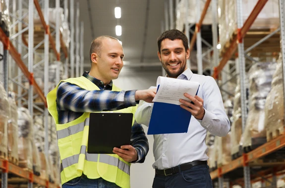 Happy People looking at an ipad in a warehouse